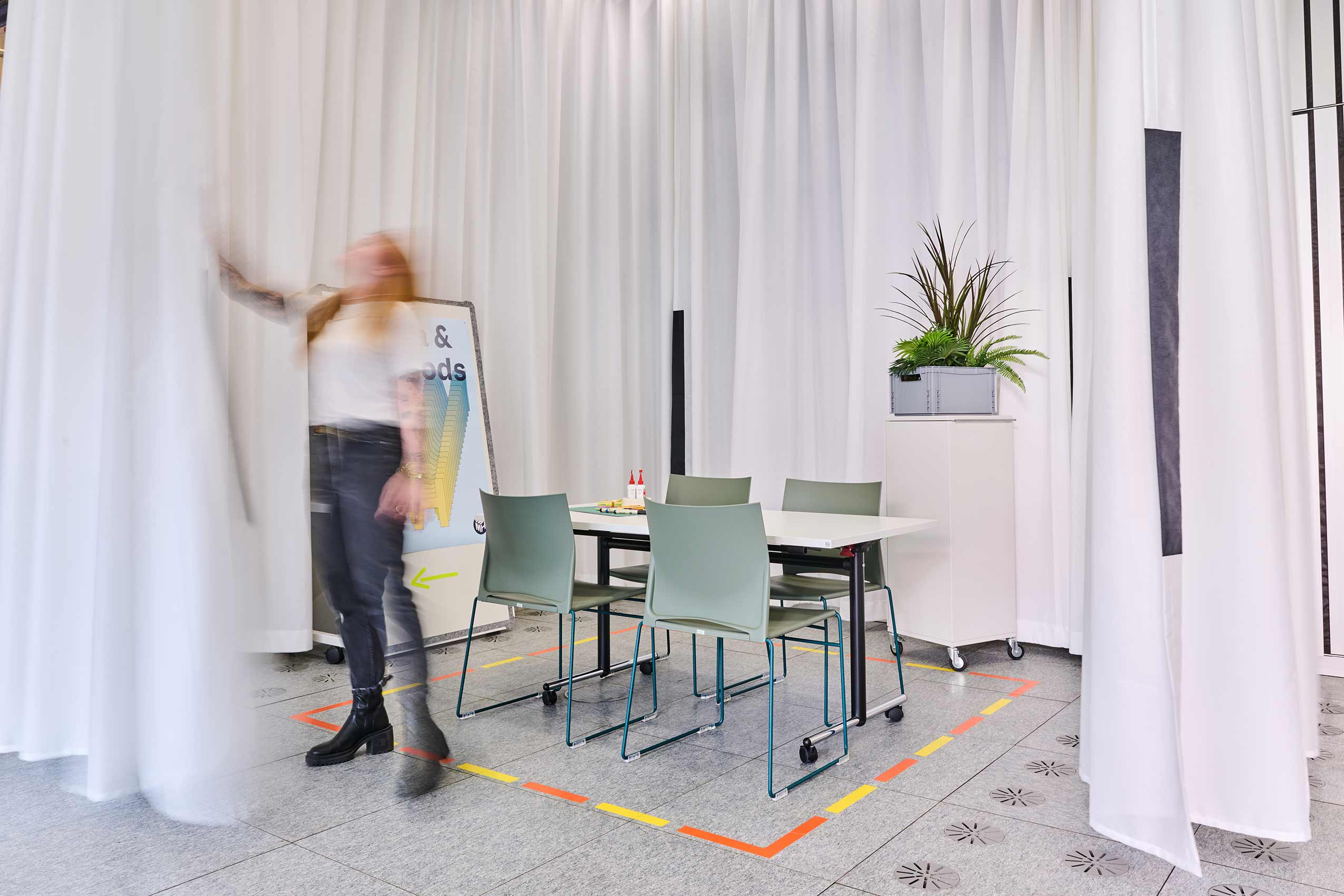 Profim Ariz chairs around a meeting table with a temporary room created by white hanging fabric