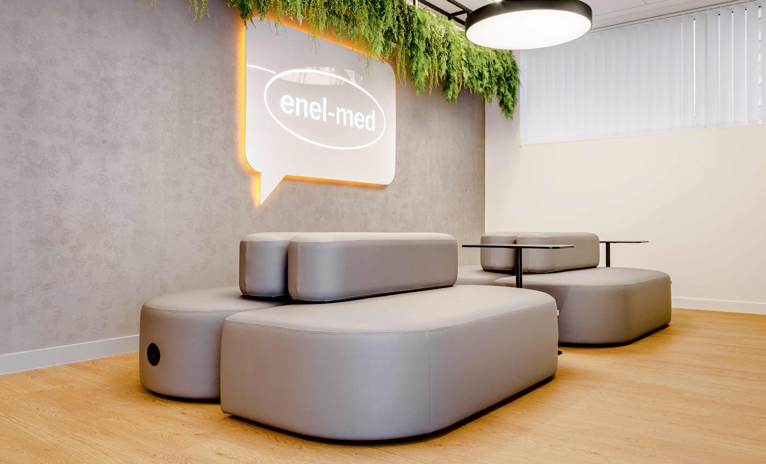 Another angle of hospital waiting room with grey walls and yellow floor, and Profim Revo sofas