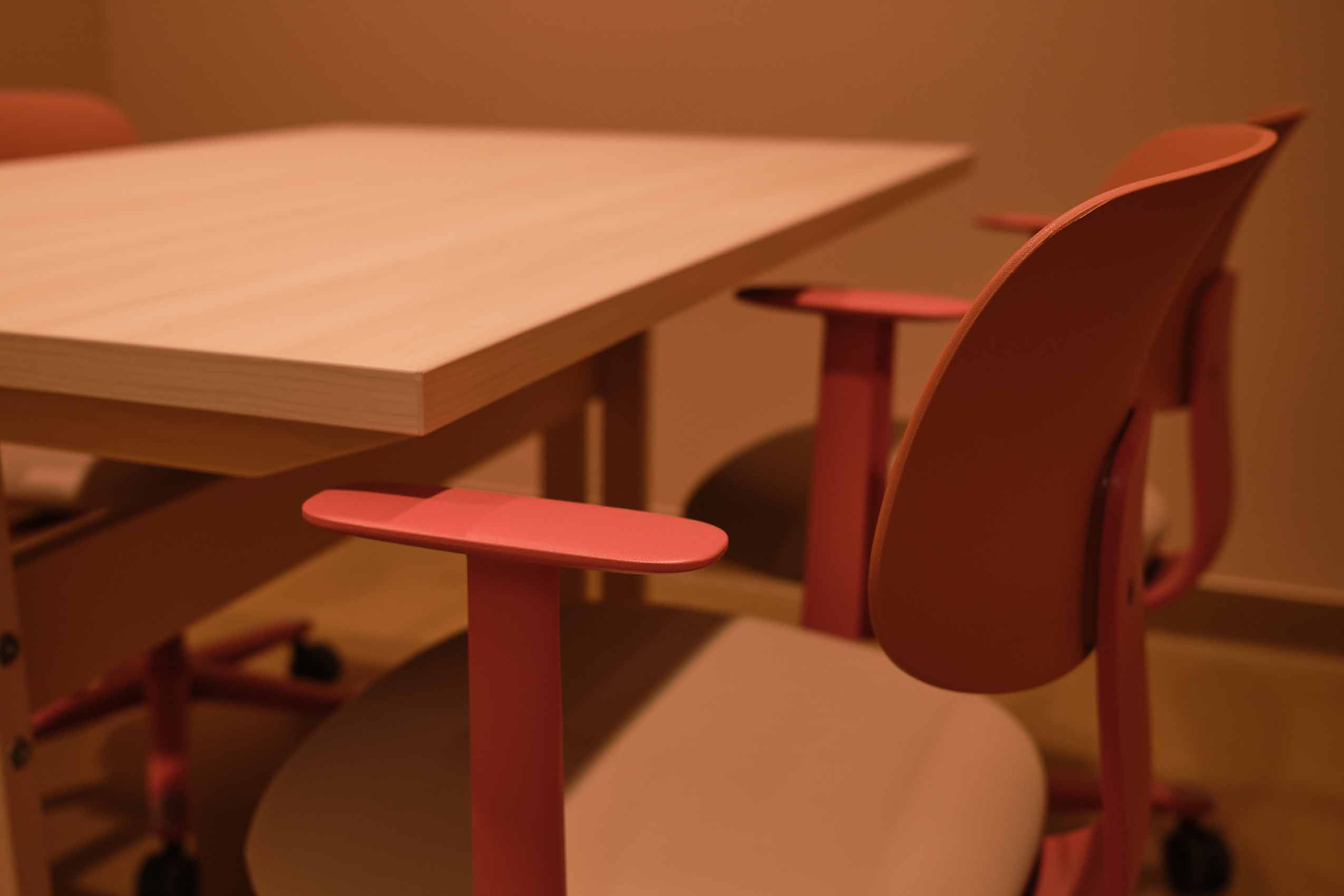 close up on HÅG Tion chair in red with armrests just under the table