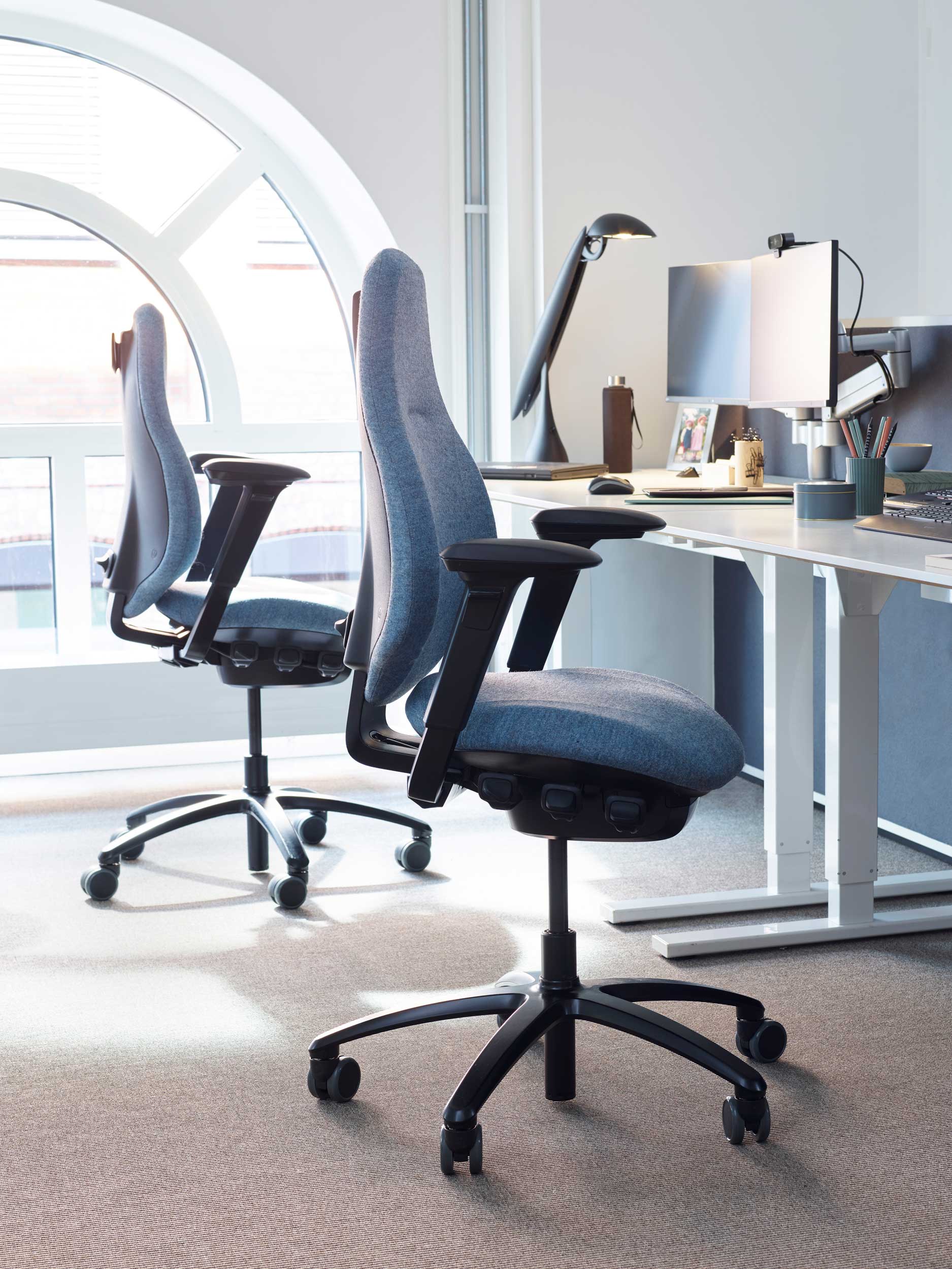 Close up of Inside FotoWare's office, 2 RH Mereo in blue fabric in front of workstation desks