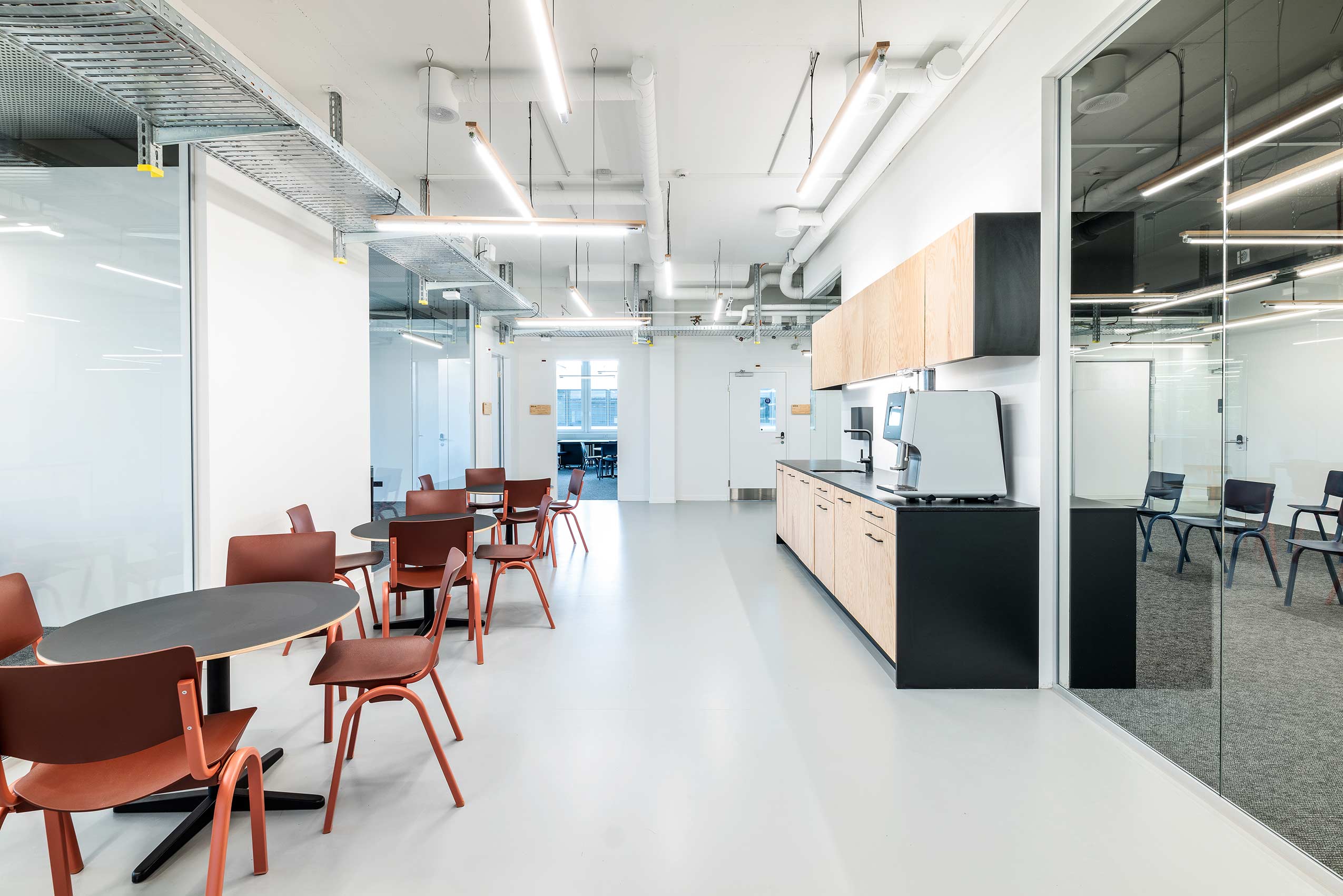 kitchen space with HÅG Celi chairs around table on the left and kitchen worksurfaces on the right