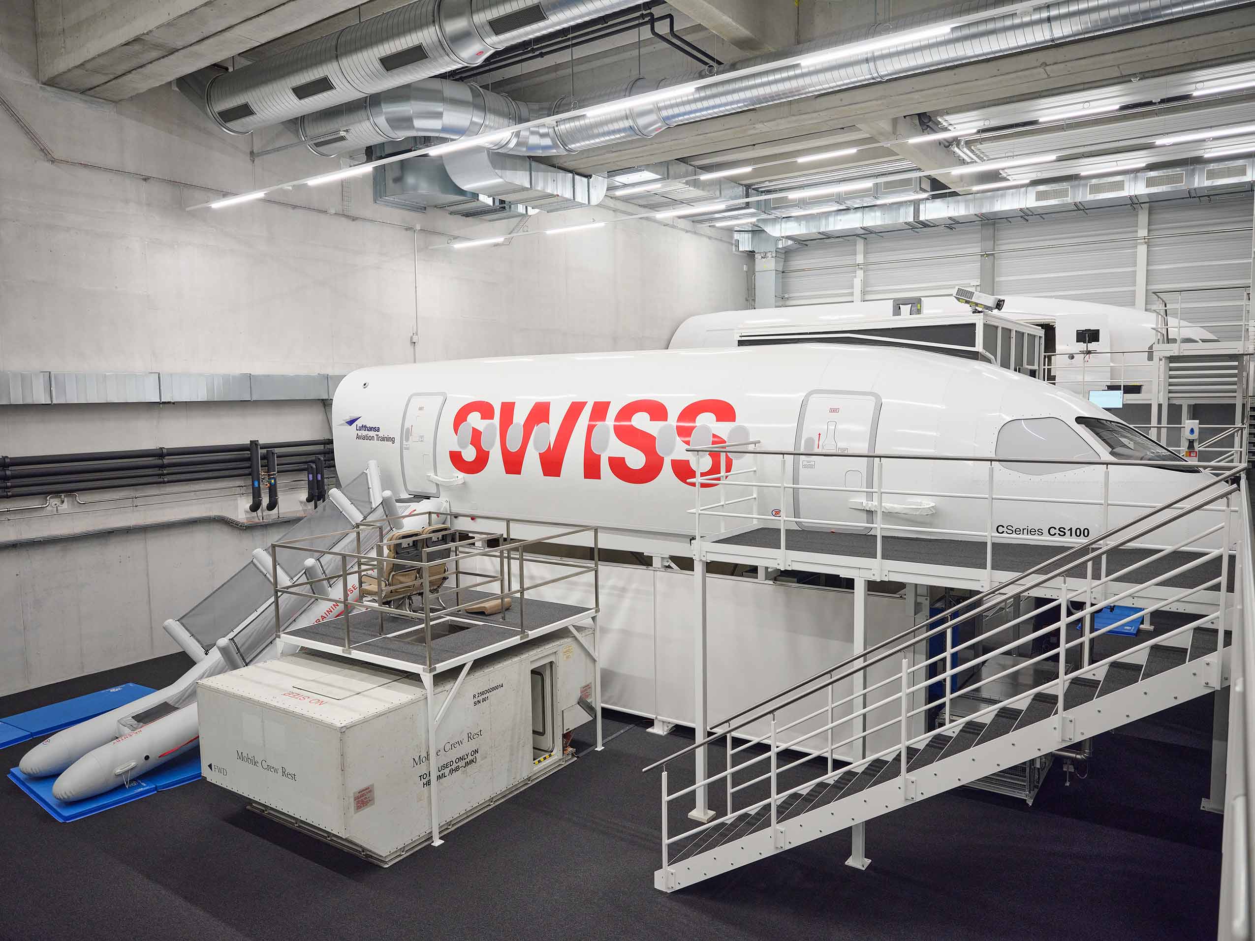 aeroplane simulator at Lufthansas training centre. a mock from of a plane is visible. inside a white building accessible by a gantry