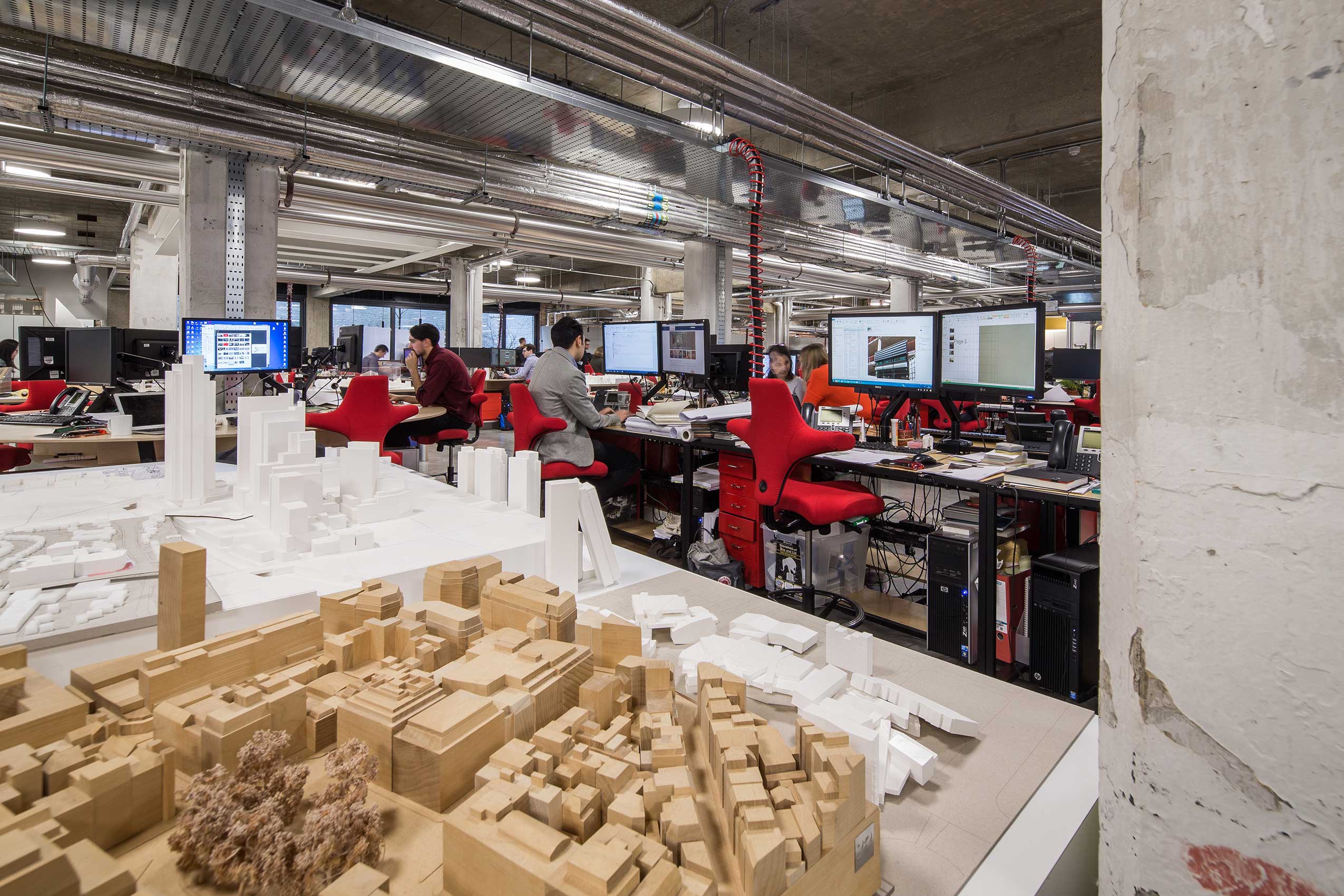 interior of make architects office, with bright red HÅG Capisco chairs