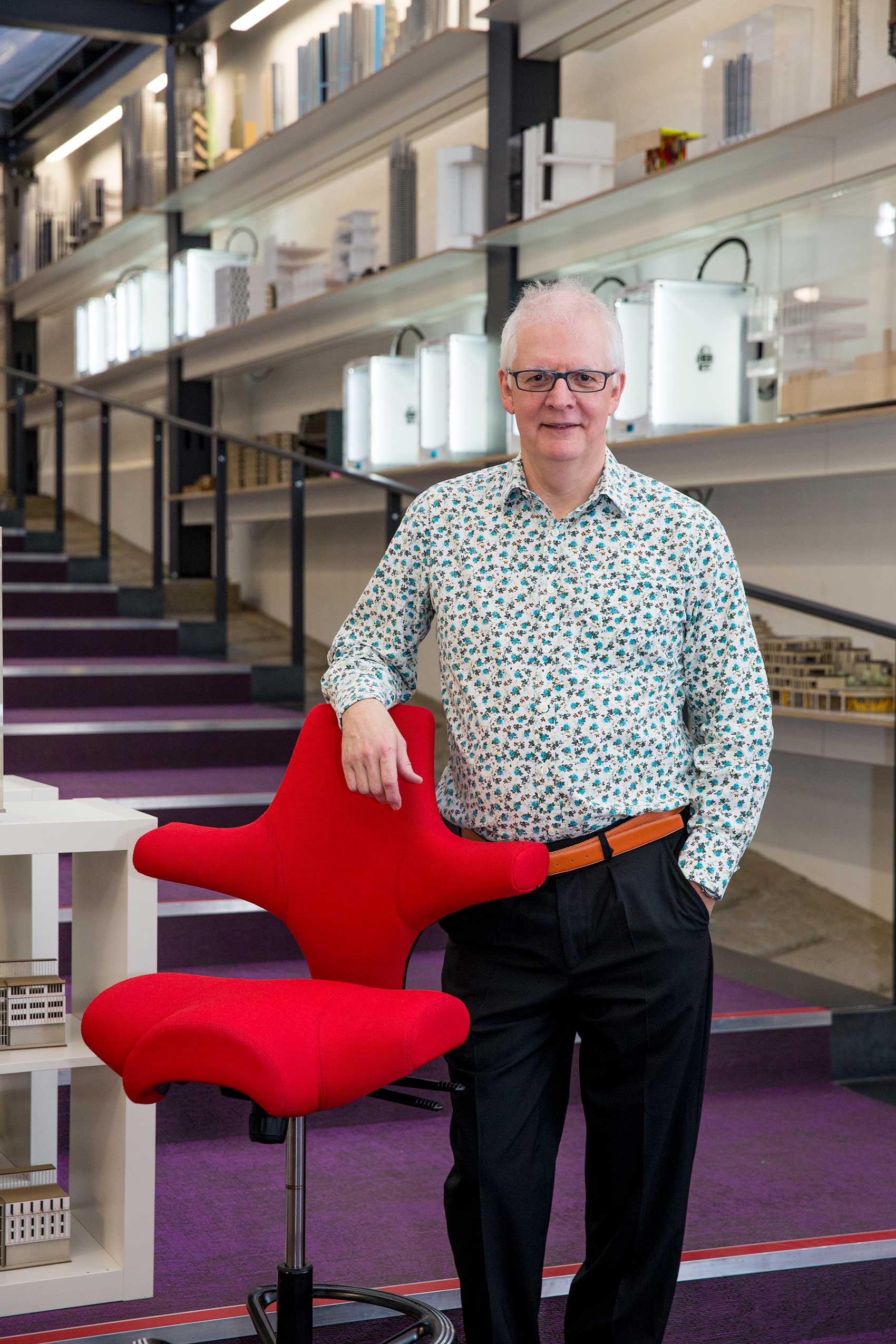 Ken Shuttleworth, founder of Make architects, standing with a HÅG Capisco chair