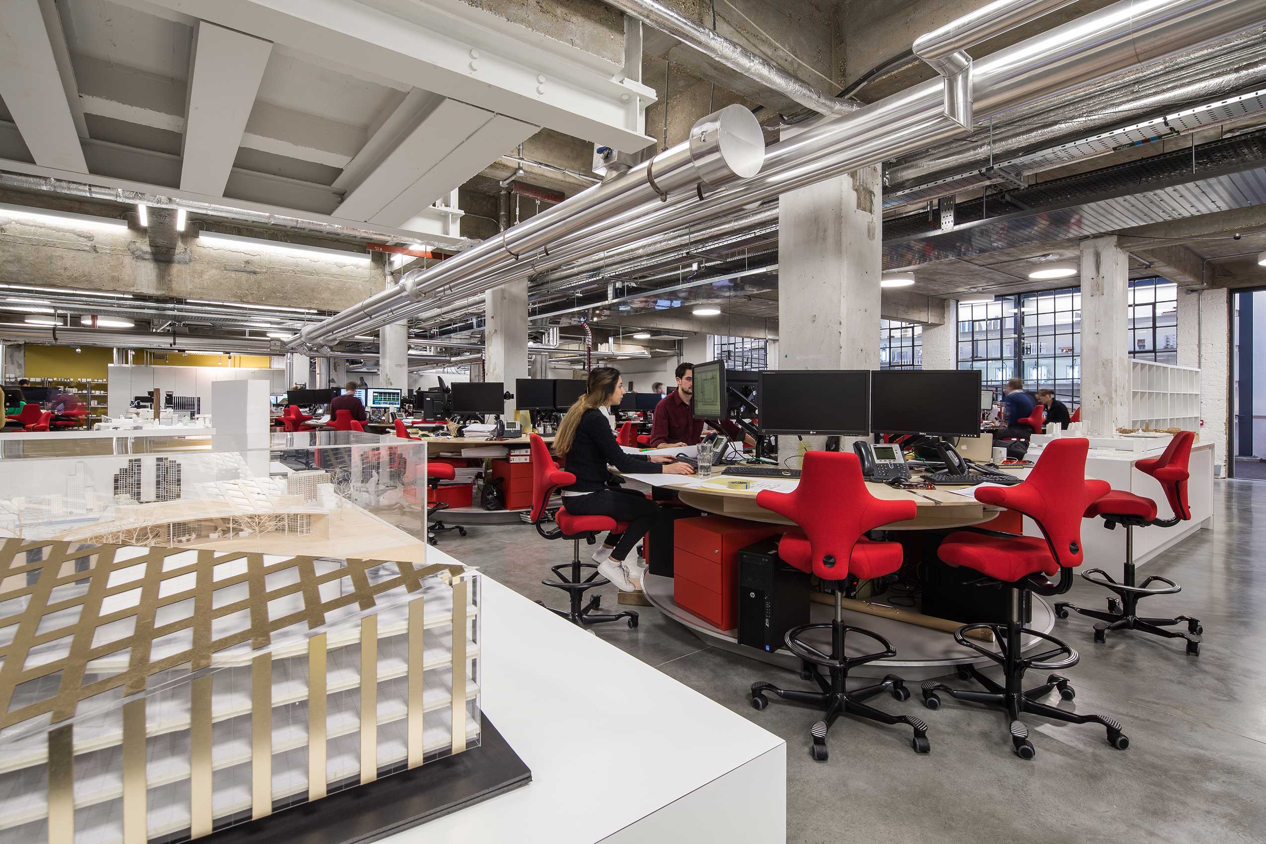interior of make architects office, with bright red HÅG Capisco chairs