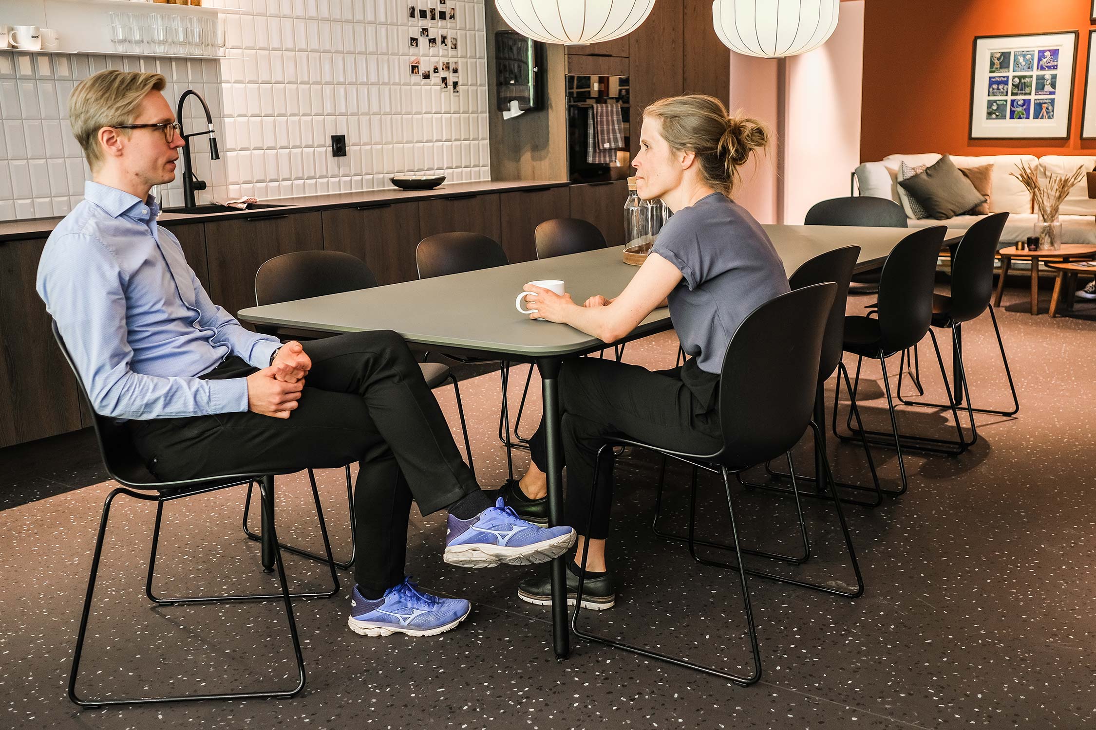 2 people sat at a table on RBM Noor chairs, in an office collaboration area 