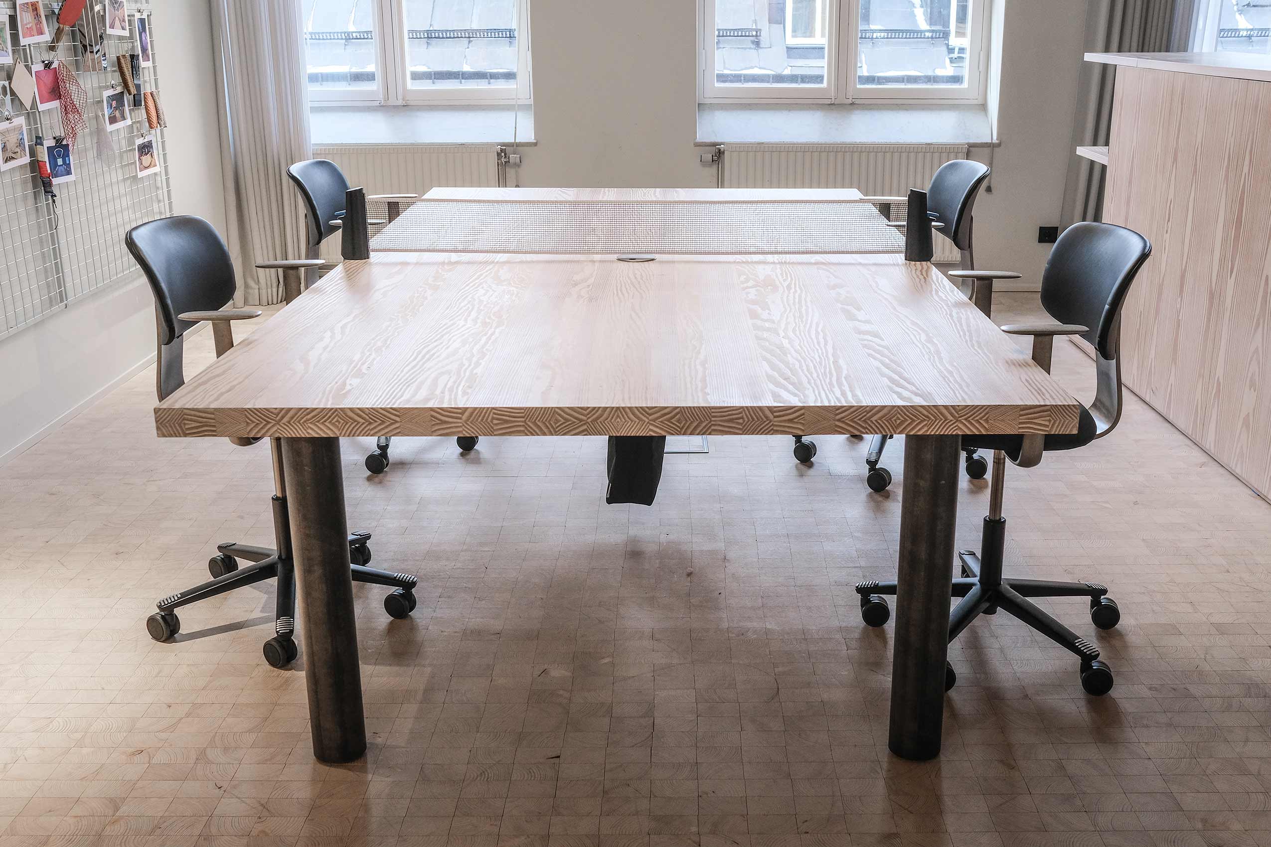 four HÅG Tion chairs around a large wooden table in an office meeting room
