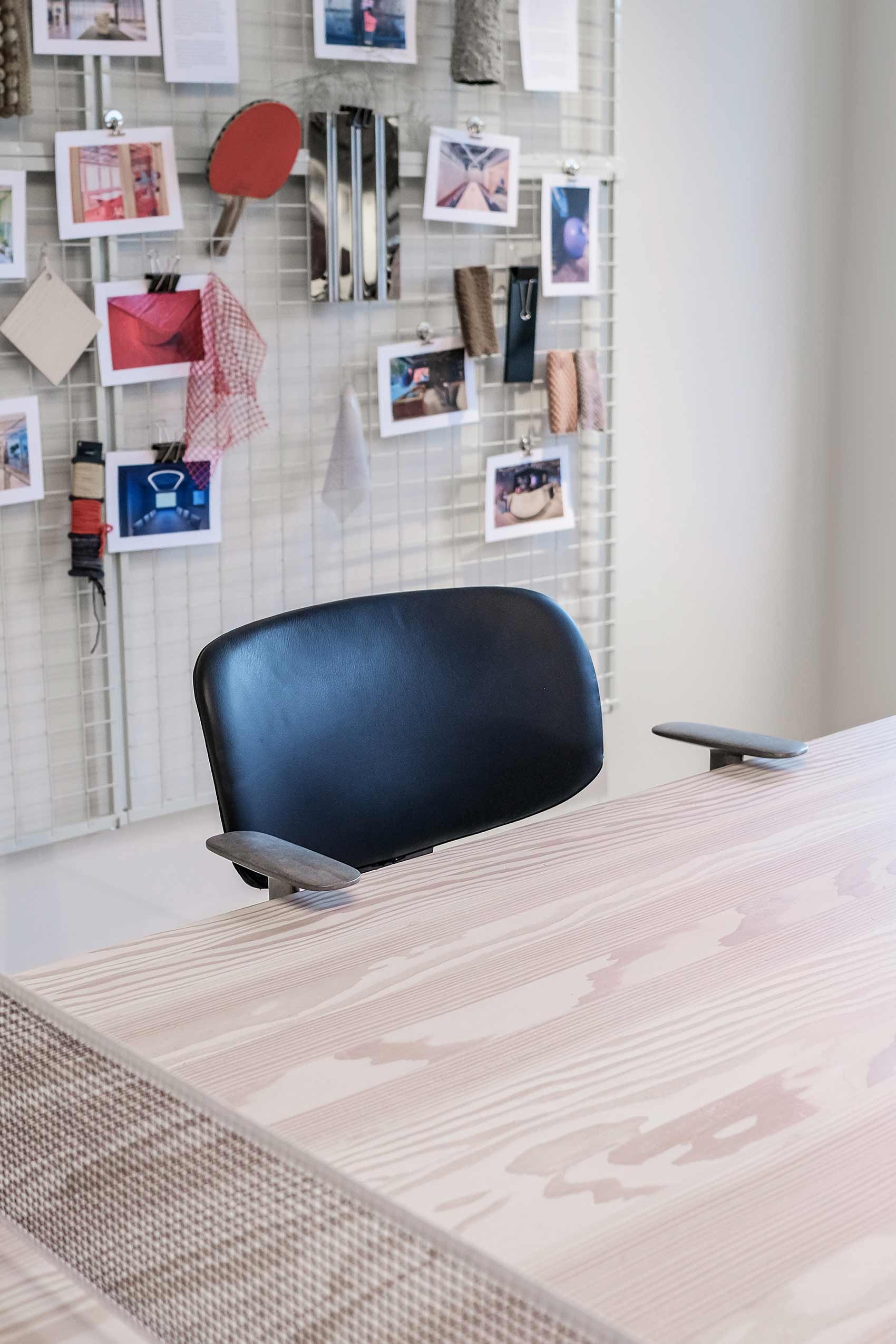 HÅG Tion chair behind a wooden desk, in the background you can see a moodboard of pinned images
