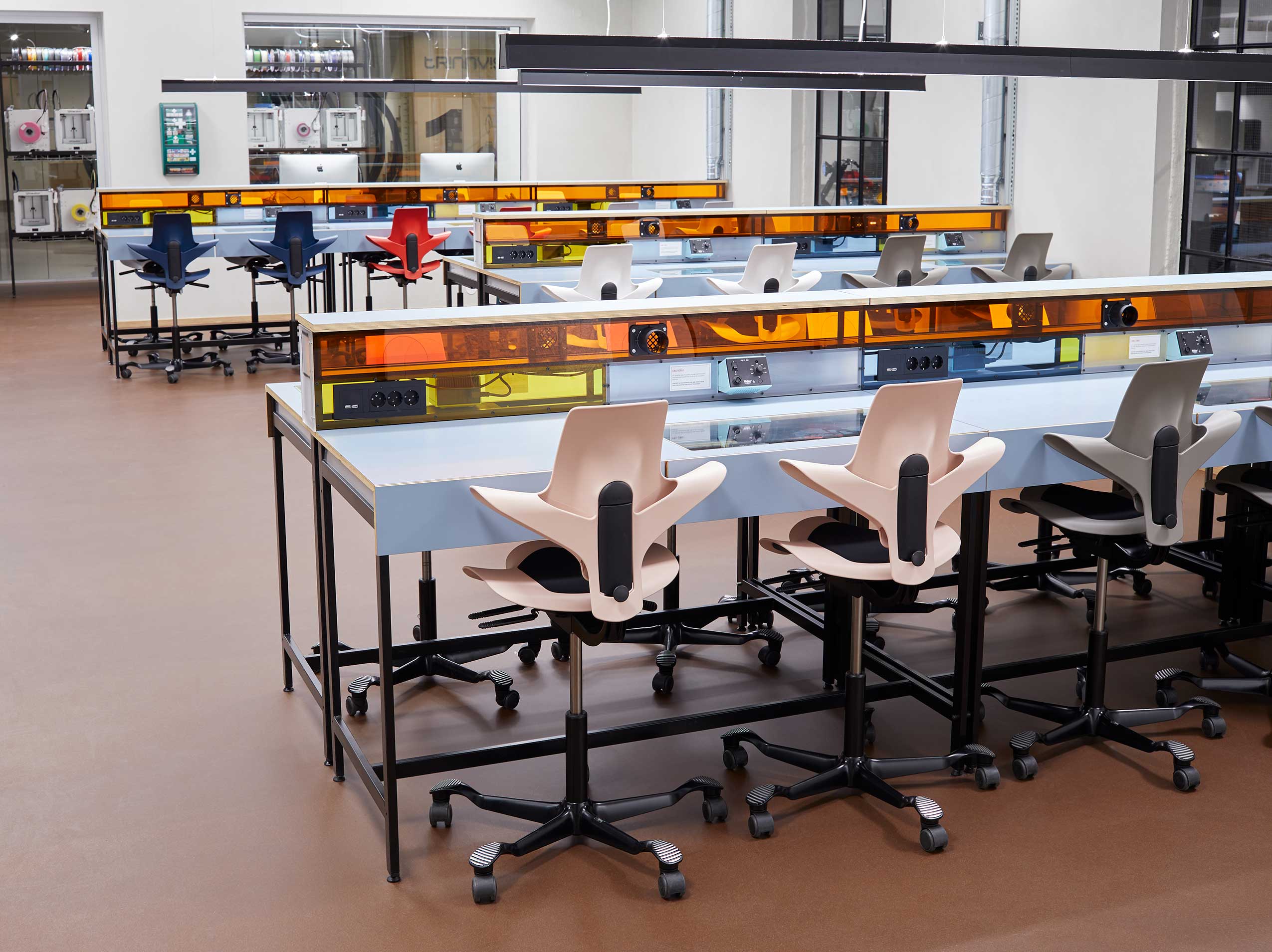 colourful HÅG Capisco Puls chairs at workstatins with electric sockets at Teknolab, Oslo