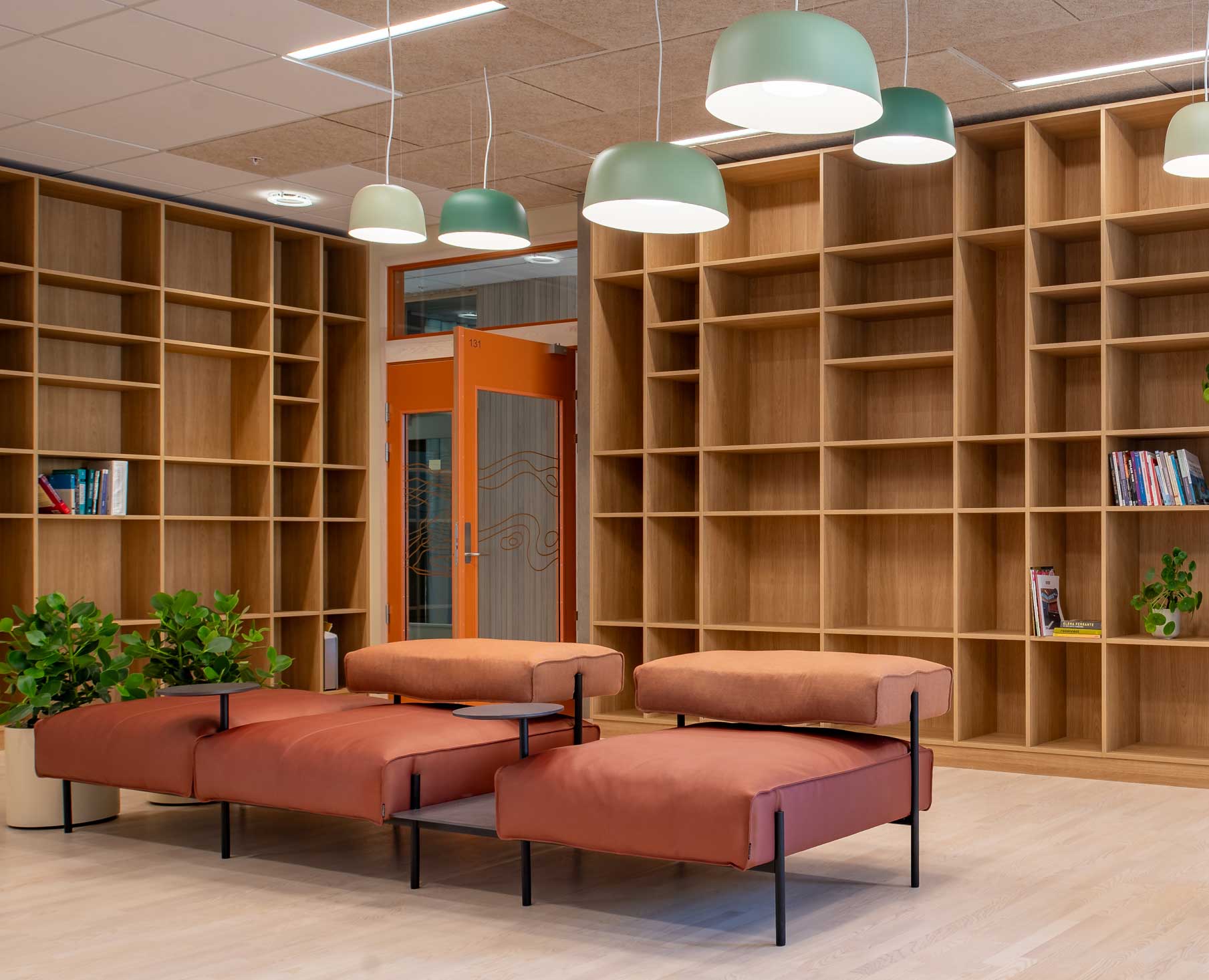 library room with walls of empty wooden shelves with cubby holes, and an offecct lucy chair in the middle of the room