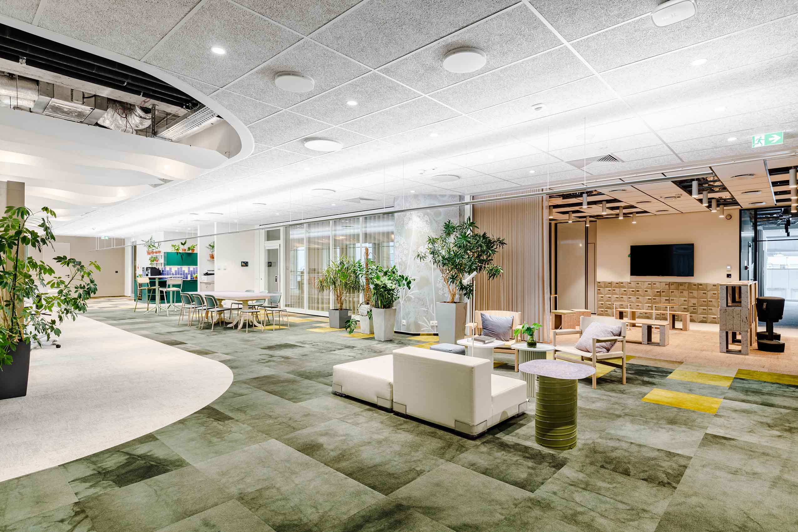 Interior of Arup's office with green carpets wooden panelling and an open seating arrangement