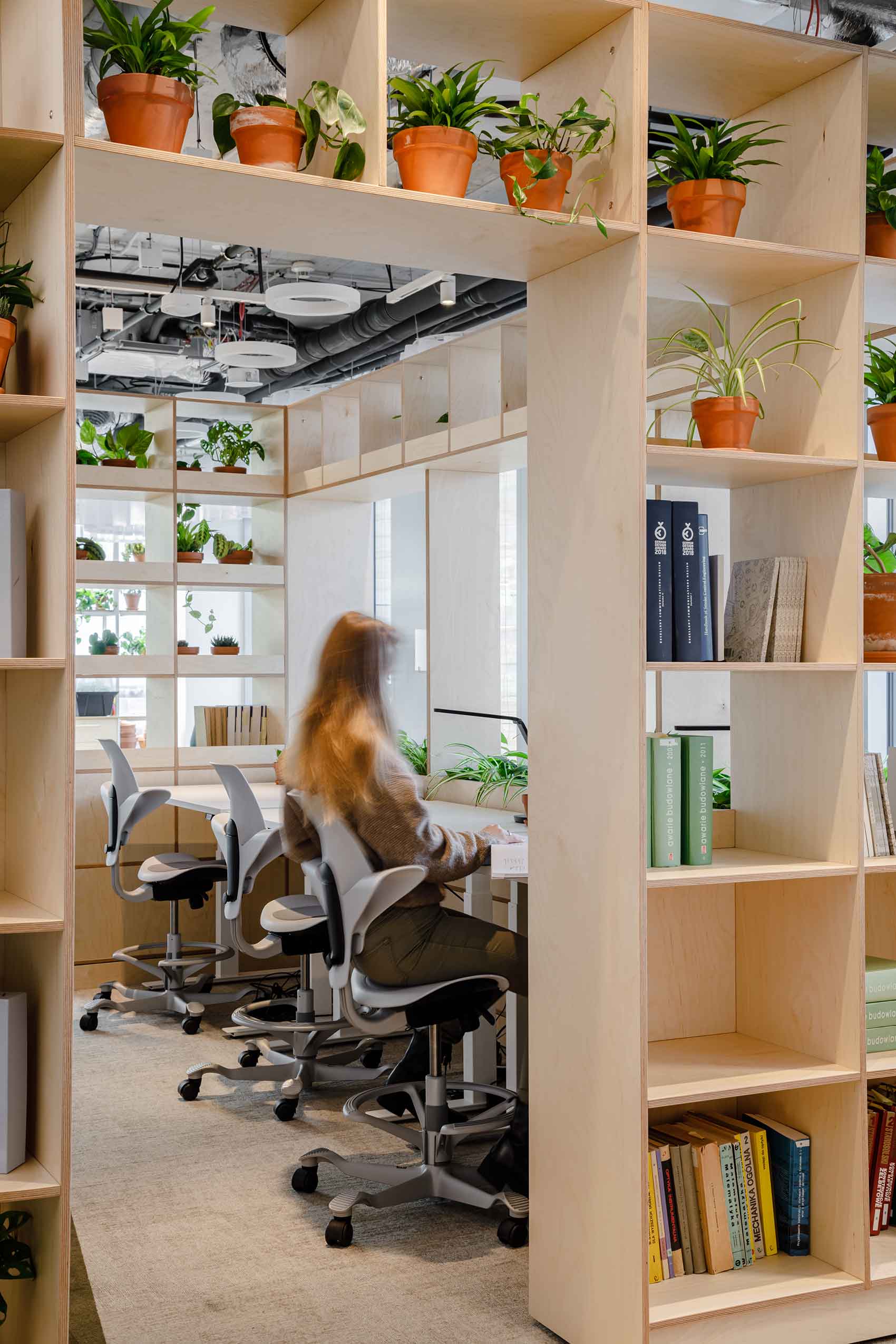 HÅG Capisco Puls seating in an office with wooden shelfing filled with plants