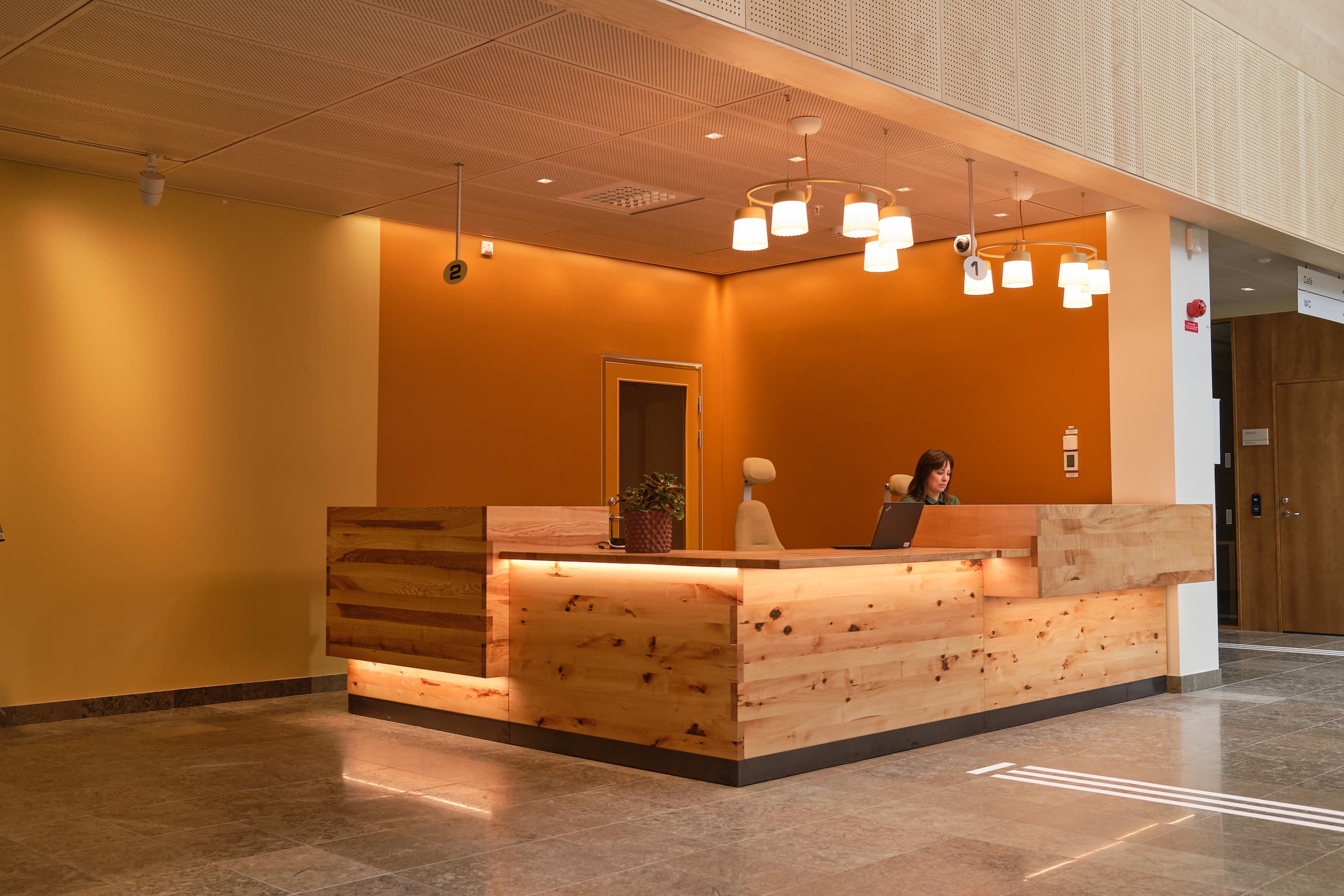 front desk at Ersta Hospital - a wooden reception area with 2 RH Mereo chairs and a receptionist sat at a computer