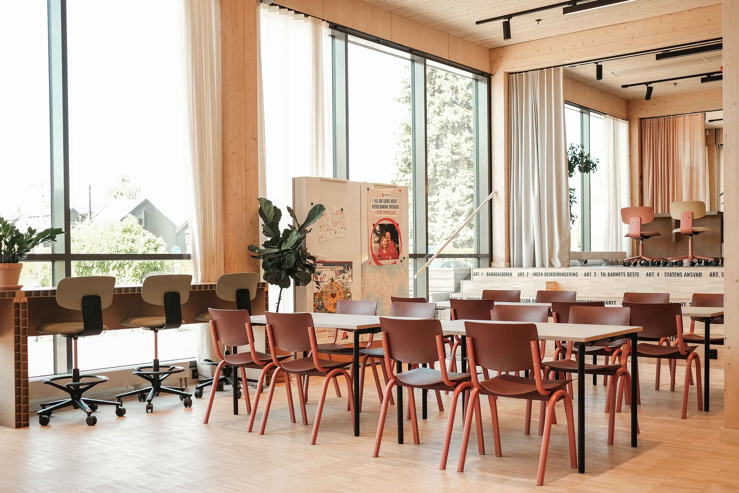 interior of Redd Barna office, featuring various Flokk chairs in warm colours