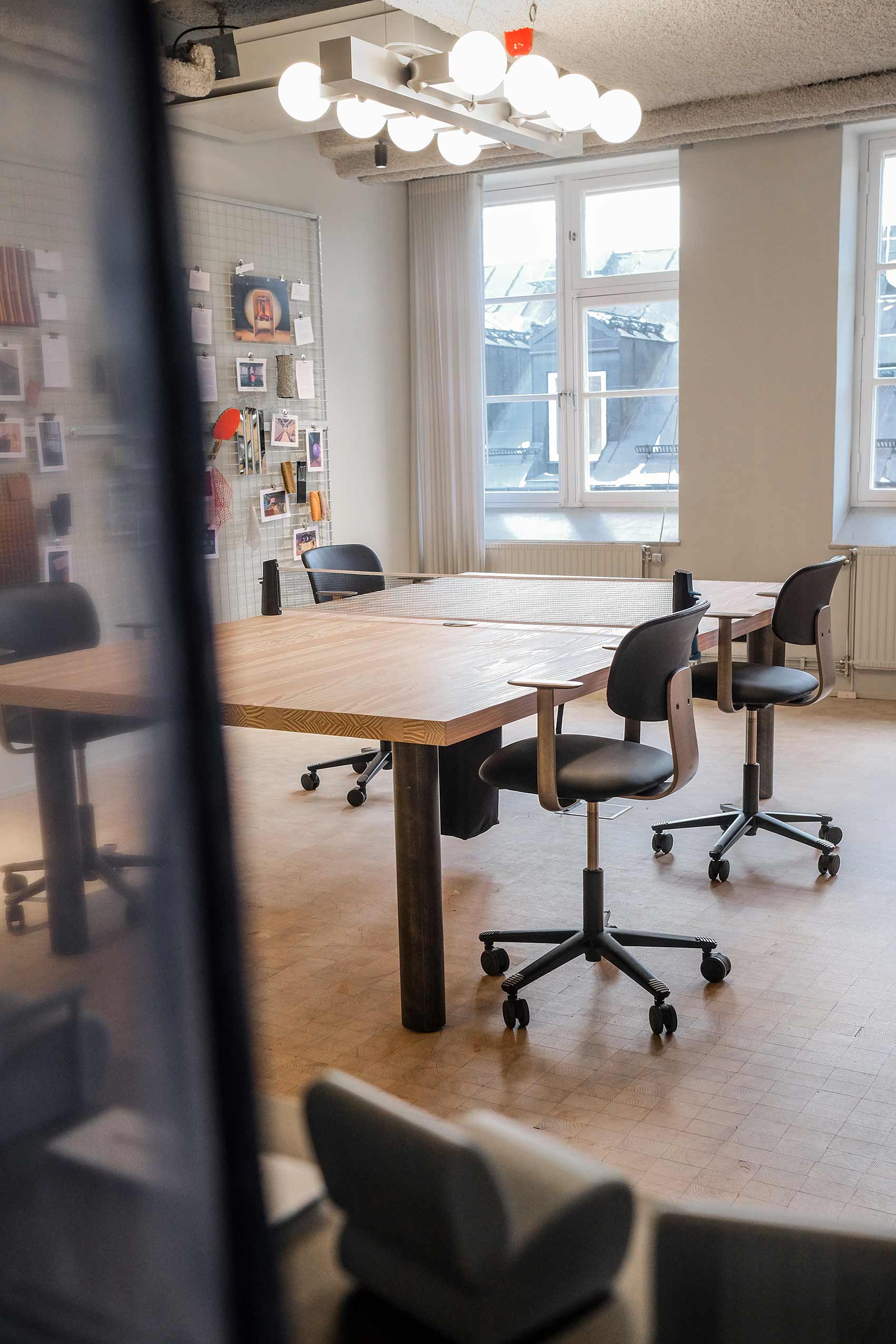 four HÅG Tion chairs around a large wooden table in an office meeting room